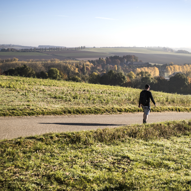 Een wandelaar wandelt alleen over een wandelpad met uitzicht over het heuvelland.
