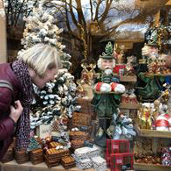 Vrouw bekijkt Aachener printen in etalage