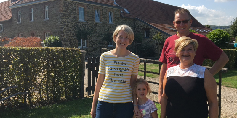Vrouw en dochter poseren met eigenaren voor de vakantiehoeve. 