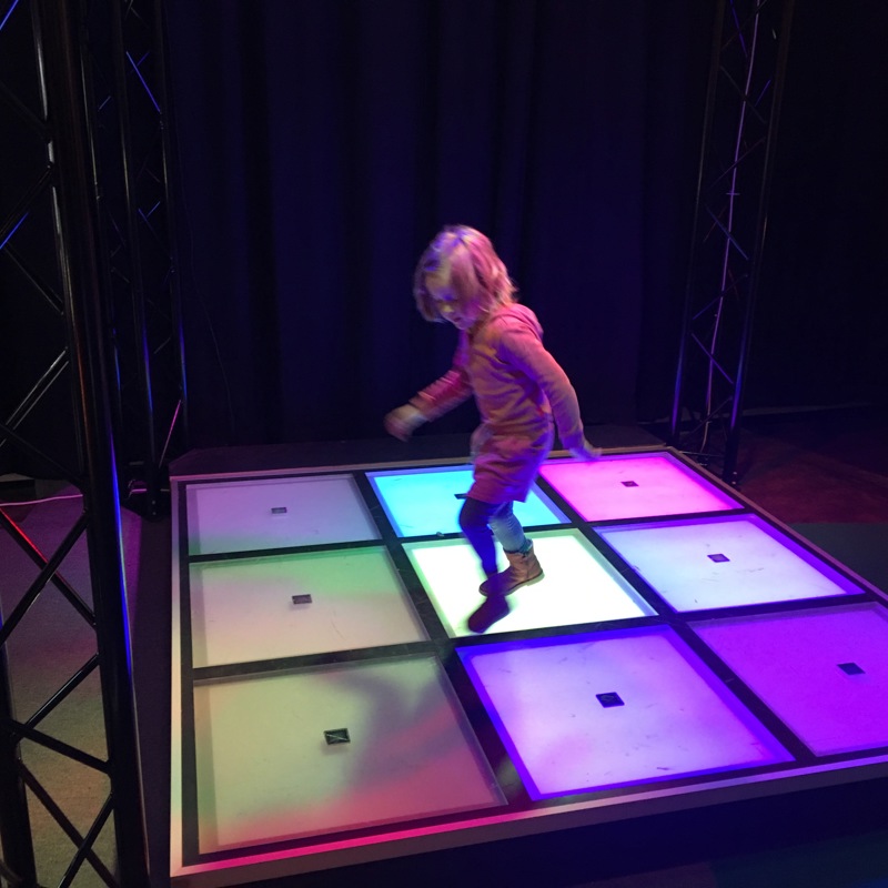 Meisje danst op verlichte dansvloer