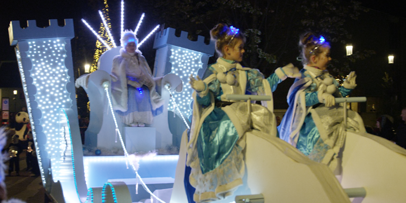 2 meisjes en daarachter sneeuwkoningin op verlichte praalwagen