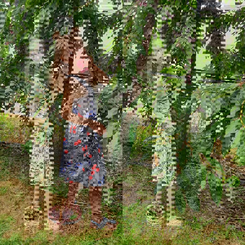 Meisje stopt geplukte kers uit boom in haar mond