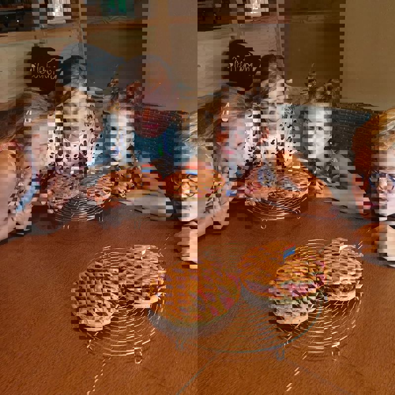 Jonge vrouw en 3 kinderen ruiken aan verschillende kersenvlaaien