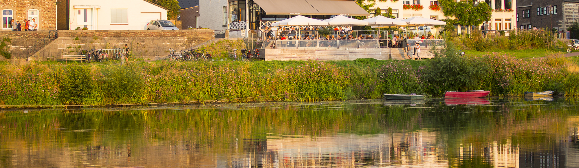 Water met roeibootjes en op de achtergrond een café met terras