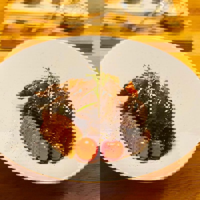 Limburgse Knien in 't Zoer op een bord, geserveerd met tomaatjes en aardappel.