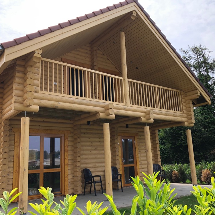 Houten huis met twee verdiepingen en een balkon. 
