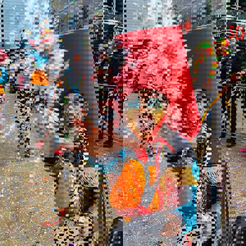 Jongetje verkleed als cowboy gooit confetti tijdens de optocht in Heerlen