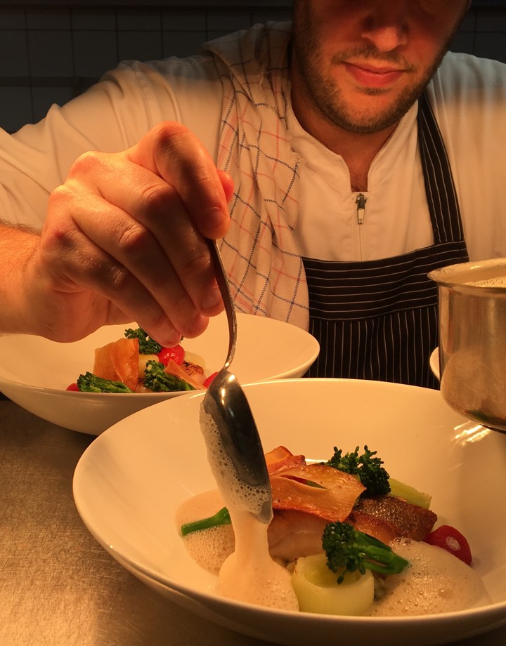 Kok die een bord opdient in een restaurant