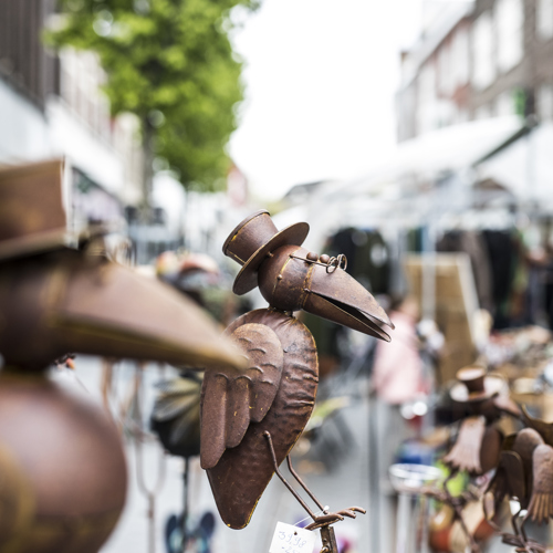Koperen beelden van vogels met een hoed en bril te koop op de markt