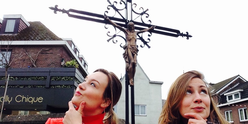 Vraagtekens voor Jenneke en Leonie met op de achtergrond een wegkruis