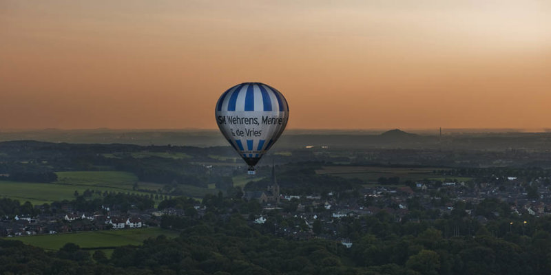 Luchtballon Boven Zuid Limburgs Heuvelland met een oranje lucht