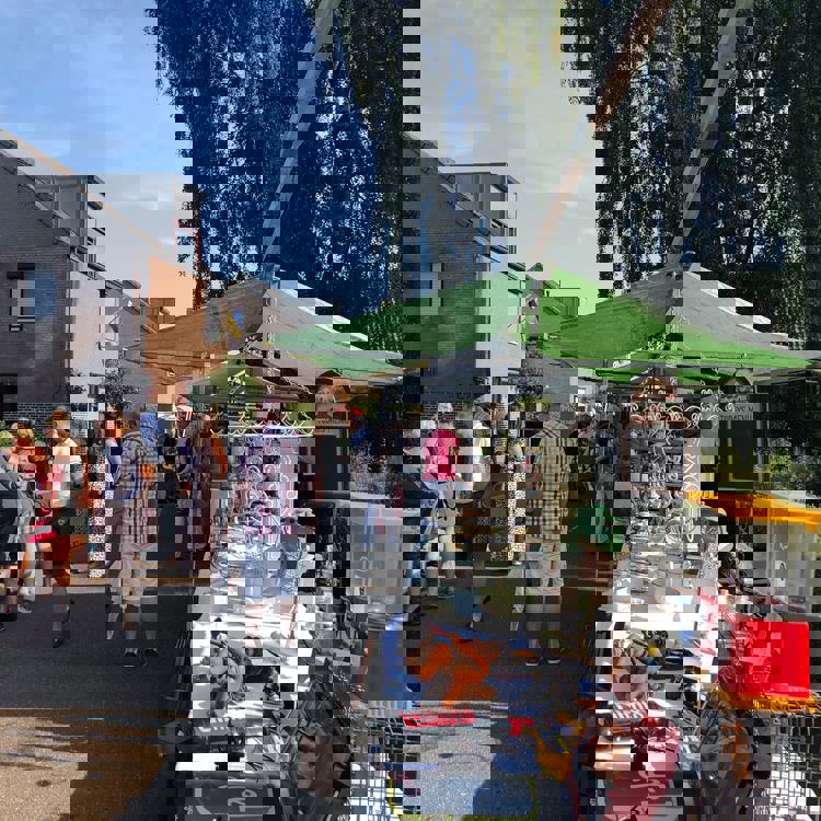 Mensen struinen langs marktkraampjes met brocante