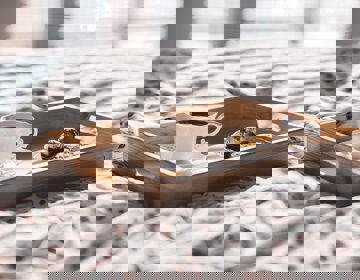 houten dienblad met koffie en bonbons op een hotelbed. 