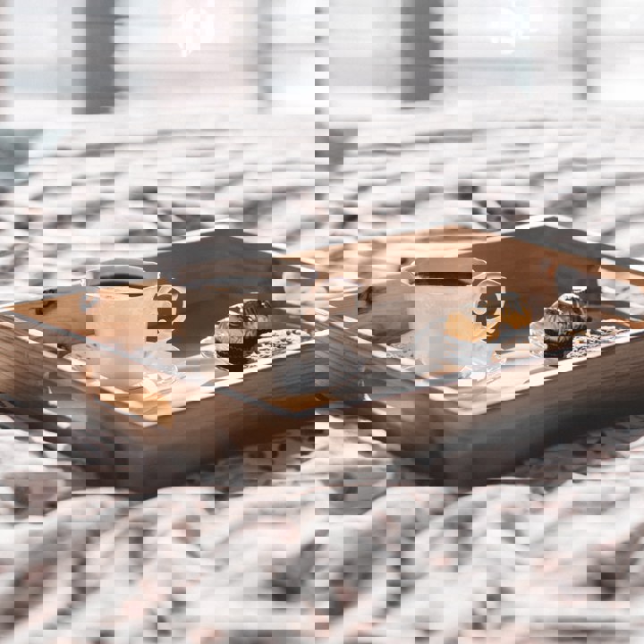 houten dienblad met koffie en bonbons op een hotelbed. 