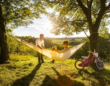 Gezin in een hangmat met uitzicht over het landschap