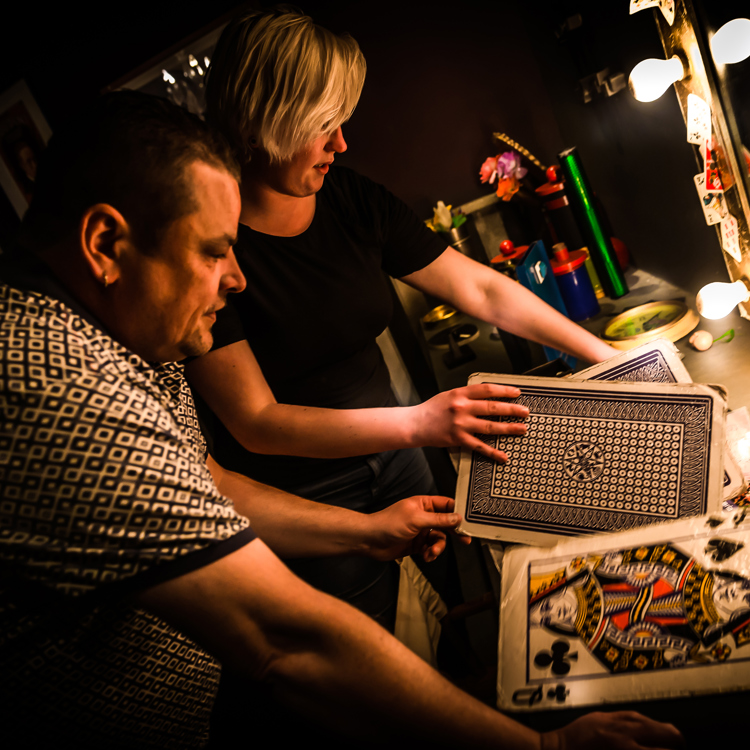 Man en vrouw met grote speelkaarten in een escape room