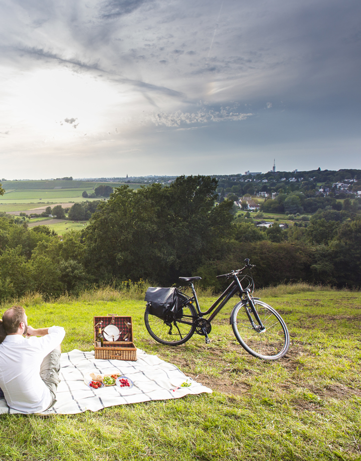 Een koppel op een picknickdeken kijkt uit over het heuvellandschap