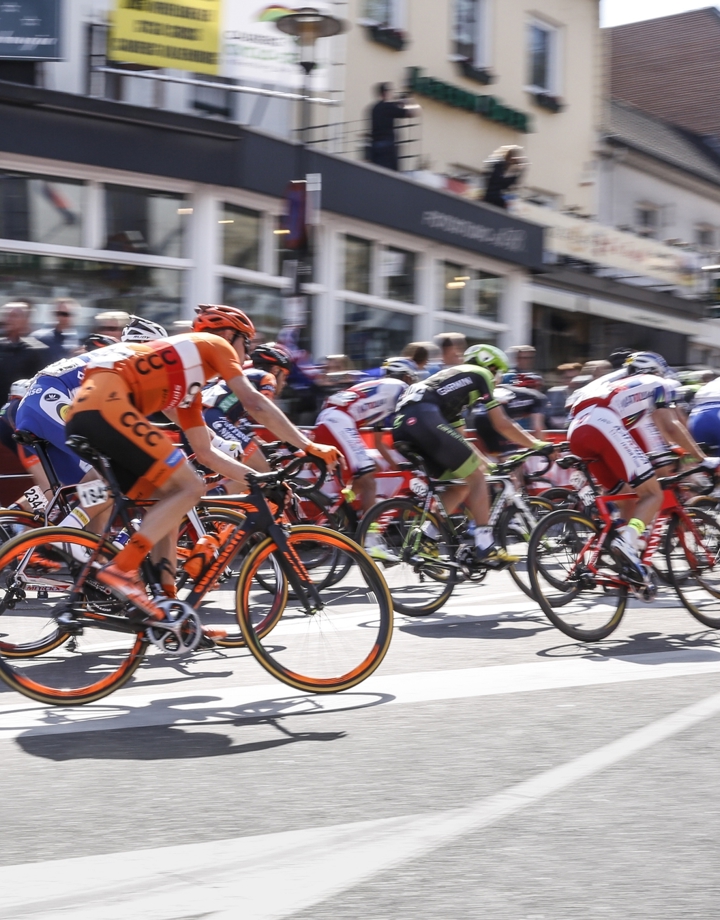 Het peloton van de Amstel Gold Race fiets door een bocht richting de Cauberg