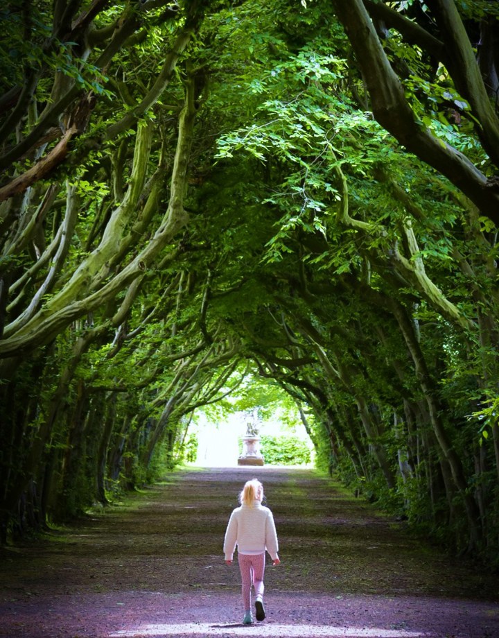 Een meisje loopt door een bomenallee bij Kasteel Eijsden