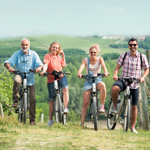Vier mensen zitten op een e-bike en lachen naar de camera