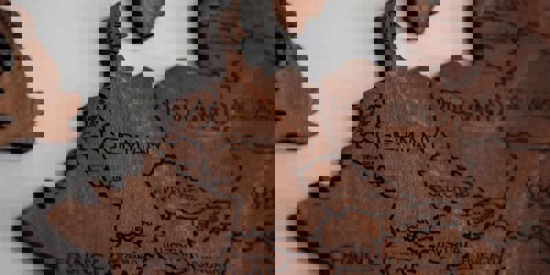 Een houten kaart van Europa, ingezoomd op Nederland en haar buurlanden