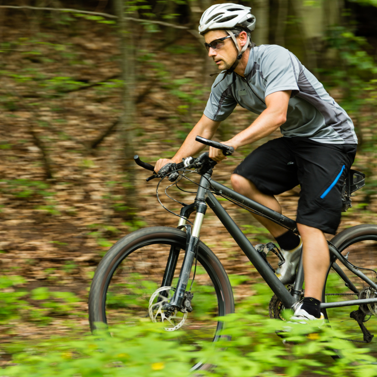 Een mannelijke MTB'er fietst over een bospad