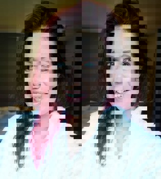 Selfie van een dame in witte badjas en rood haar. 