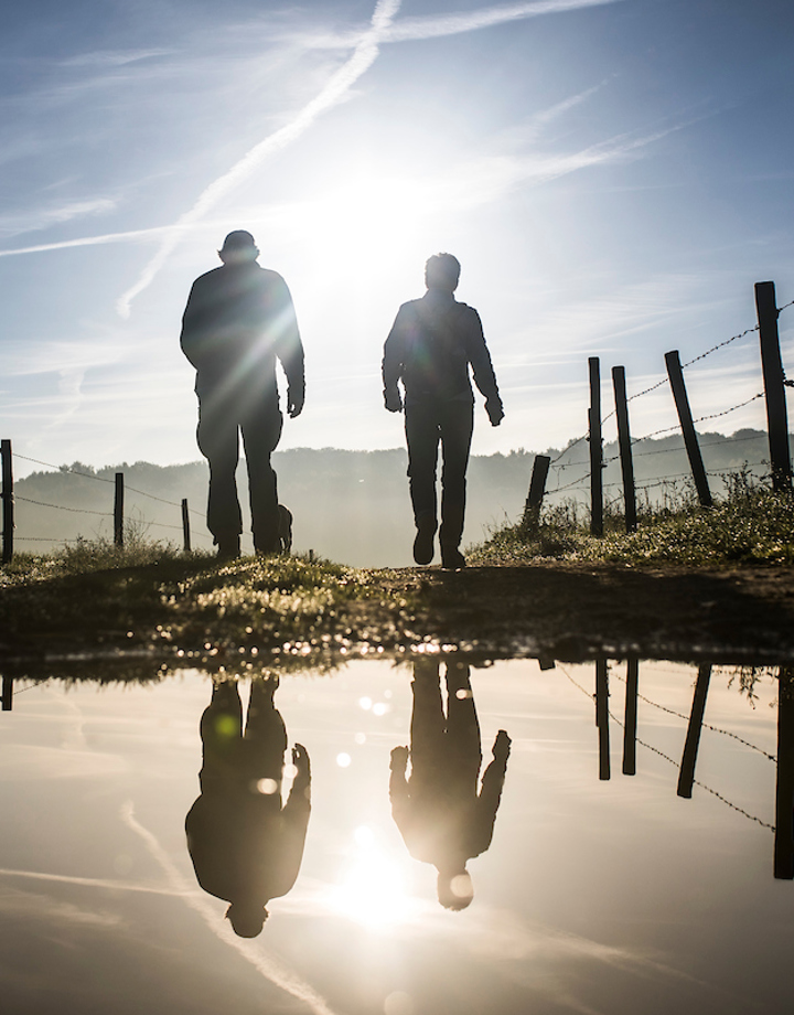 Wandelaars met reflectie in een waterplas