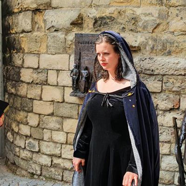 Vrouw met cape met capuchon bij de Grendelpoort in Valkenburg 