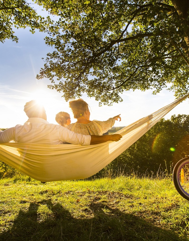 Gezin in hangmat kijkt naar het uitzicht op een zonnige dag