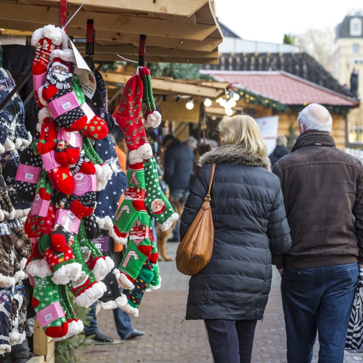 Ouder koppel loopt arm en arm struinend langs de kraampjes van Santa's Village