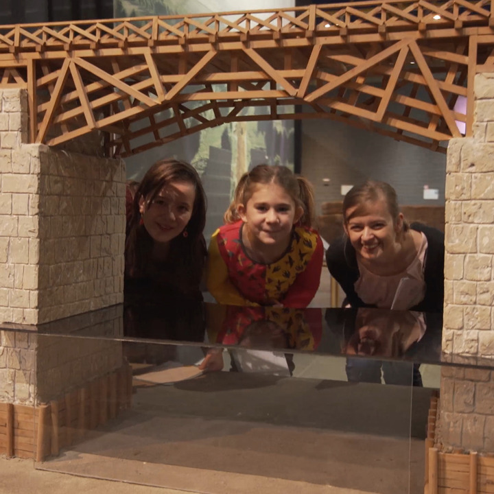 Laura en haar kidspanel poseren achter een kleine Romeinse brug in het Thermenmuseum