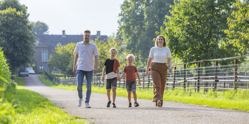 Een gezin met twee zoontjes wandelt over de toegangsweg van Kasteel Haeren in Voerendaal