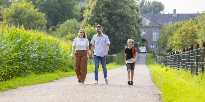 Een gezin wandelt met zoontje over de toegangsweg bij Kasteel Haeren in Voerendaal