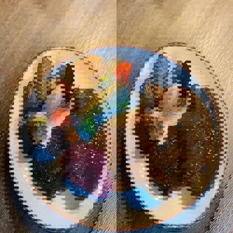 Limburgse Knien in 't Zoer op een bord, geserveerd met aardappel, rode kool en diverse groenten.