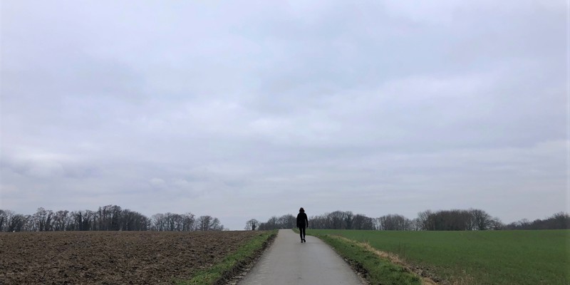 Een vrouw wandelt over een verharde weg