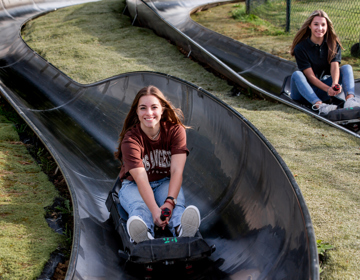 Twee meiden genieten van de rodelbaan