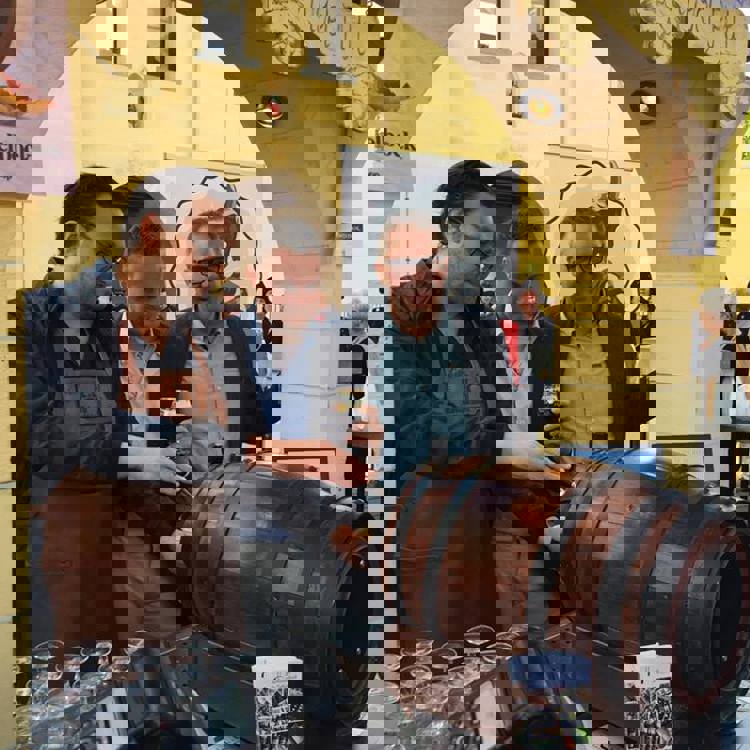 3 mannen tappen speciaal bier uit een liggend houten vat tijdens de Valkenburgse Bokkenweken