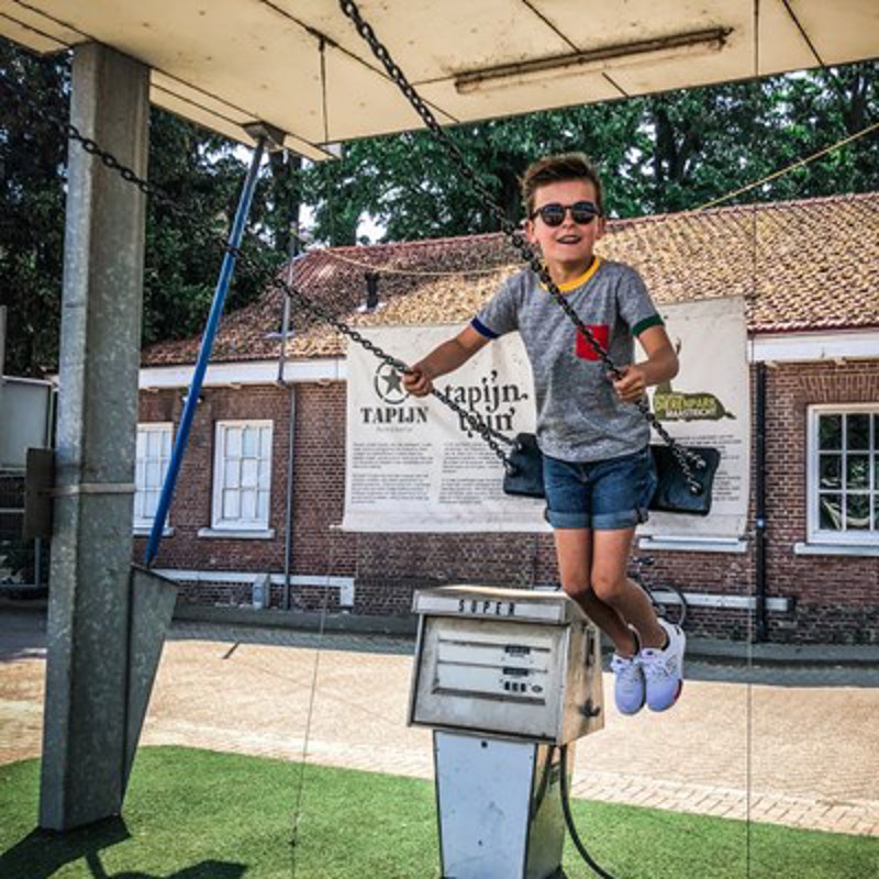 Jongetje op een schommel bij de tapijnkazerne 