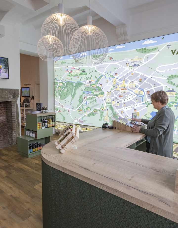 Front office medewerkster achter de balie in de Visit Zuid-Limburg Experience Valkenburg