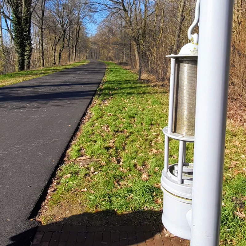 Een lantaarn die aan een paal hangt land een weg