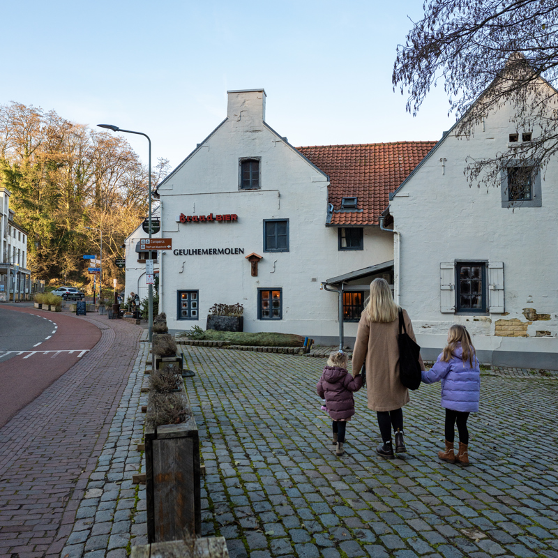 Moeder met twee dochters lopend over de stoep