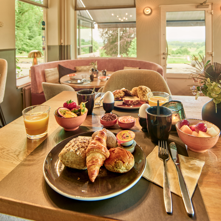 Uitgebreid hotelontbijt met broodjes, vers sap en fruit.