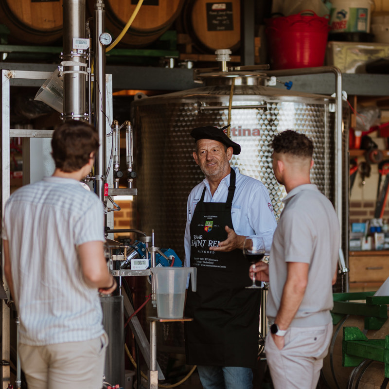 Een wijnkenner van Raar Saint Remi legt het wijnproces uit aan twee jongemannen