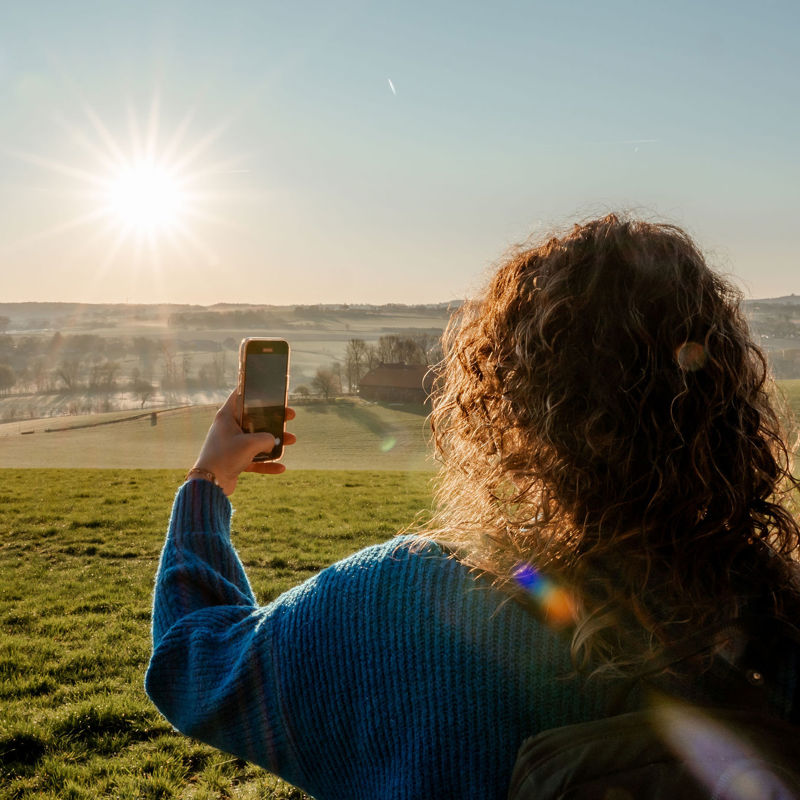 Meisje maakt met smartphone een foto van het uitzicht op de Gulperberg