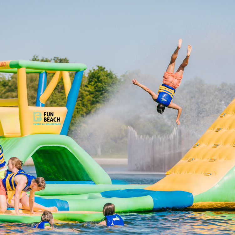Kind vliegt door de lucht op aquapark op natuurwater.