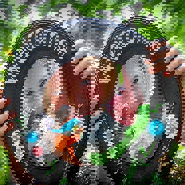 Meisje kijkt door welkomstornament met kabouter